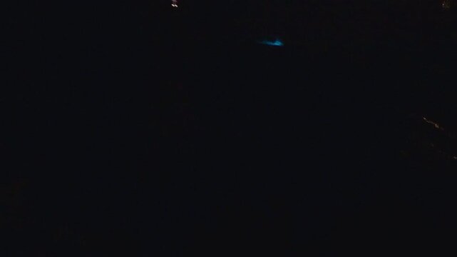 Night Paddle Hitting Dark Water Causing Bright Blue Bioluminescent Plankton Glow With Dynamic Splash And Trails In First Person View Creating Magical Marine Nature Energy And Motion