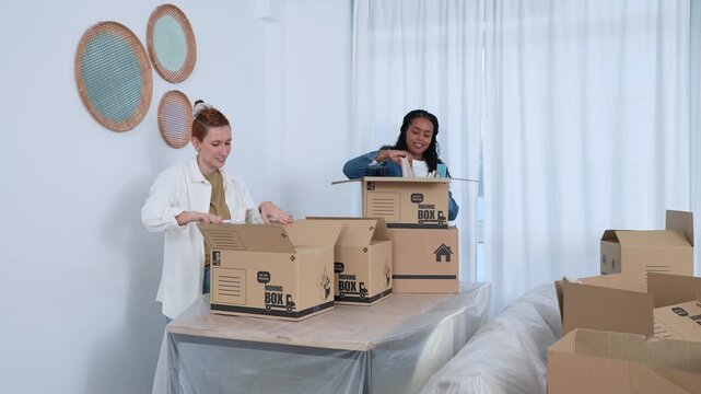 Lesbian couple unpacking moving boxes together in new home