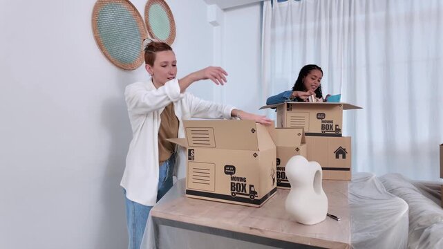 Lesbian couple packing belongings into boxes for moving day