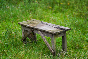 High Angle View of Weathered Rustic Wooden Bench in Green Grass