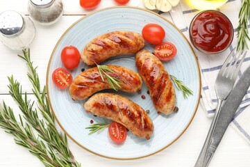 Tasty grilled sausages, tomatoes, spices and rosemary served on white wooden table, flat lay