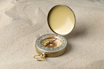 One vintage compass on sand, closeup view © New Africa
