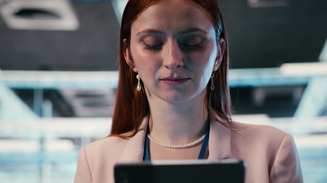 Server farm IT specialist using tablet app to do network management. Data center computer scientist uses touchscreen device to oversee equipment rackmounts, camera B close up