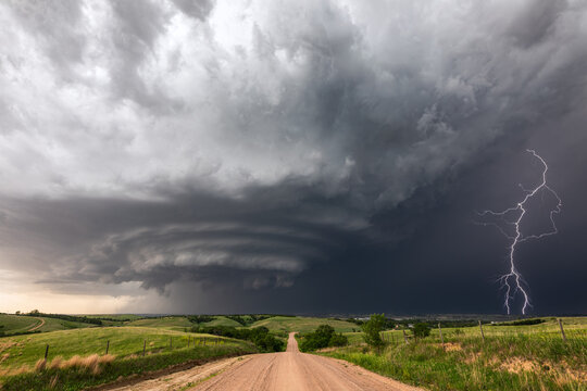 Lightning strike from a supercell thunderstorm over a dirt road