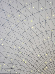 Fototapeta premium Geometric white ceiling grid with triangles and star-like lights
