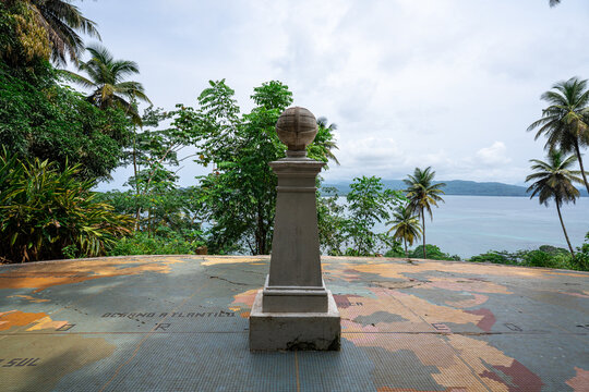 A stone geographic monument topped with a globe standing on a tiled world map at the Equator crossing on Ilh&eacute;u das Rolas, S&atilde;o Tom&eacute; and Pr&iacute;ncipe.