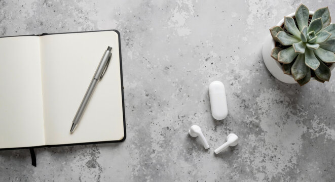 Minimalist Concrete Office Desk Flat Lay with Open Notebook and Tech Accessories