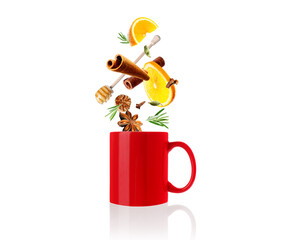 Mulled wine recipe. Spices and other ingredients falling into red cup against white background