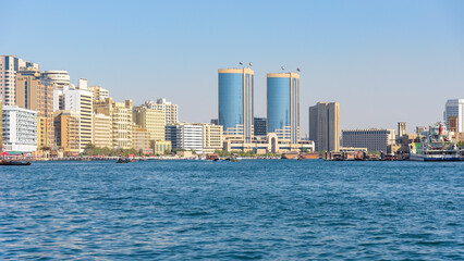 Obraz premium Modern skyline of Dubai Creek with traditional boats in the UAE