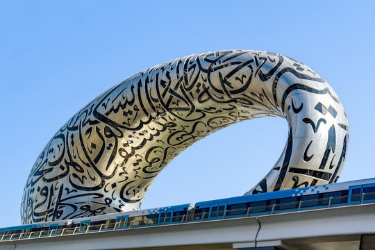 Museum of the Future in Dubai with passing metro train