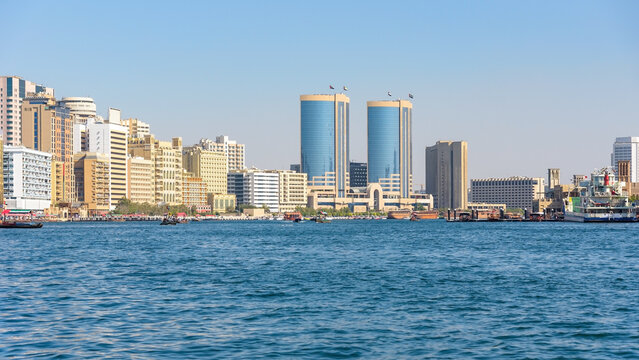 Modern skyline of Dubai Creek with traditional boats in the UAE