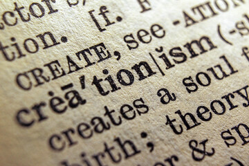 Word creationism printed on a dictionary page, macro closeup