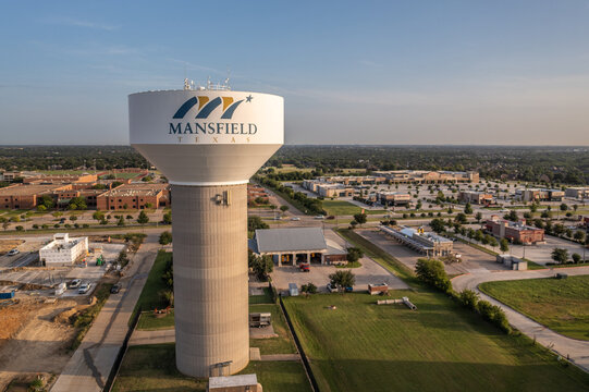 Aerial Drone View of White Mansfield Water Tower Near Buildings in Downtown of Mansfield, Texas