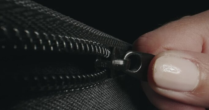 A zipper slowly opening on luggage bag at customs controll, slow motion