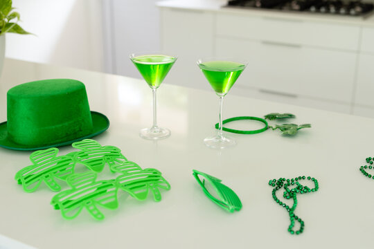 St Patrick's Day decorations and two green cocktails are being arranged on glossy white countertop