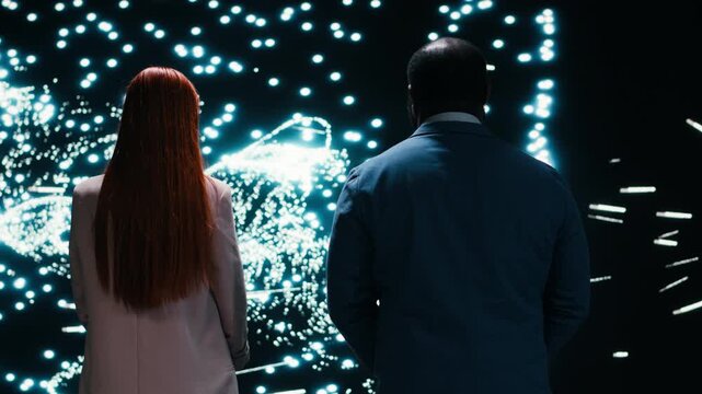 Monitoring AI model, AR projection and engineering team collaborating on cognitive systems. Studying neural network activity, laptop and coworkers in RD tech startup brainstorming, camera B