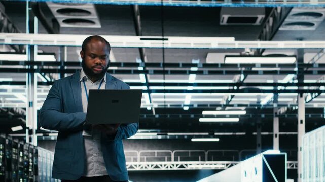 Team of server farm software developers using laptop to optimize electronics. Data center teamworking colleagues brainstorming, using notebook to monitor system performance bottlenecks, camera B