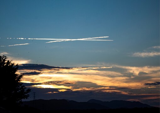 Sunset with airplane condensation trails