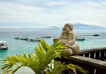 Colorful traditional outrigger boats anchored off Mushroom Beach on Nusa Lembongan, Bali, with Mount Agung visible in soft morning light across the Bali Sea. © Simon