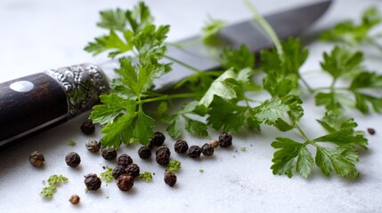 Fototapeta premium Parsley sprigs, a sharp knife, and peppercorns rest on a white surface, viewed up close.