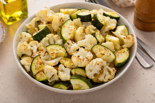 Roasted cauliflower and zucchini with garlic and herbs in a serving bowl