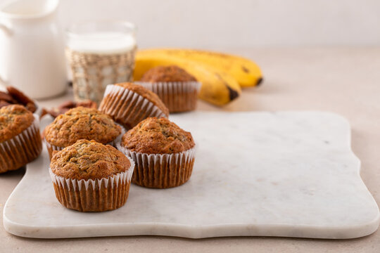Banana muffins with pecan nuts freshly baked on a cooling rack with copy space