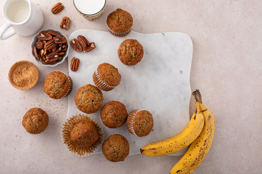 Banana muffins with pecan nuts freshly baked on a cooling rack overhead with copy space