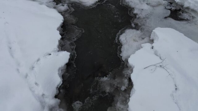Rivi&egrave;re gel&eacute;e dans la for&ecirc;t en hiver. Magnifique paysage hivernal avec sa rivi&egrave;re gel&eacute;e. Paysage d'hiver au drone. Neige sur la rivi&egrave;re.