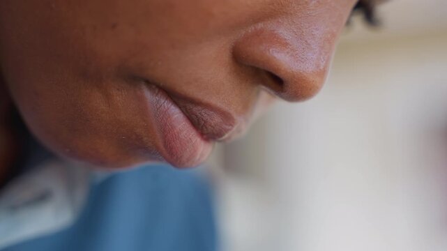 Black woman pausing after cleaning chores, closeup profile with soft light, blue shirt, quiet domestic pause, tired yet relieved expression, indoor window background, reflective household moment