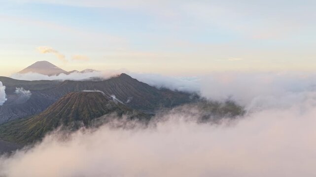 Amazing aerial view of the bromo, batok and semeru volcanoes rising above a sea of clouds at sunrise in east java, indonesia