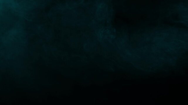 Wispy cyan smoke flows gently across the frame, creating a cinematic and moody atmosphere on black background