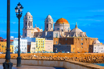 Stunning Cadiz Cathedral in Cadiz, Spain, glowing under a bright blue sky beside the ocean. Its golden dome and historic architecture create breathtaking coastal view © Leilani