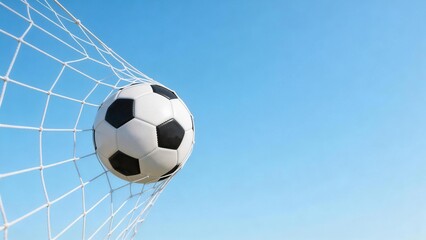 Soccer ball in goal net against blue sky