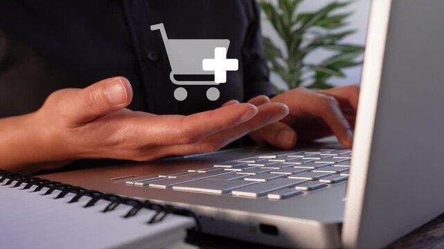 Close-up of a businesswoman's hands working on her laptop while holding an animated shopping icon with the "add" button. Add more products to your cart.