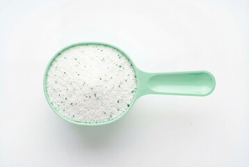 Overhead view of laundry powder in green scoop