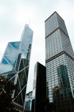 A dramatic upward view captures the soaring geometric forms of the Bank of China Tower and the ICBC Tower, as their glass and steel fa&ccedil;ades converge against the sky.
