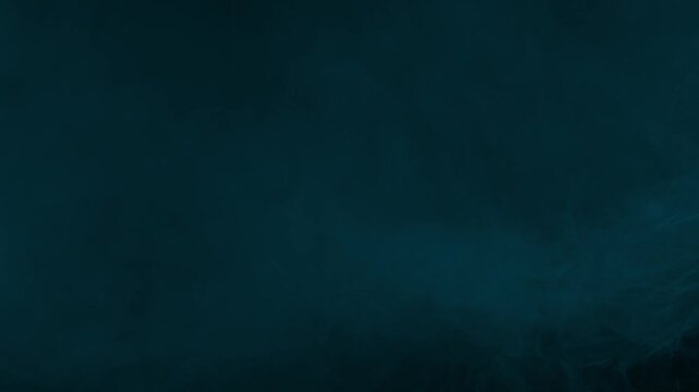 Ethereal and ghostly wisps of cyan smoke drift slowly, creating a supernatural atmosphere on black background