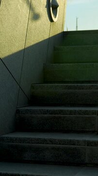 A vertical tilt shot revealing modern corporate architecture with blue glass windows and granite stairs. Perfect for real estate and urban design content.