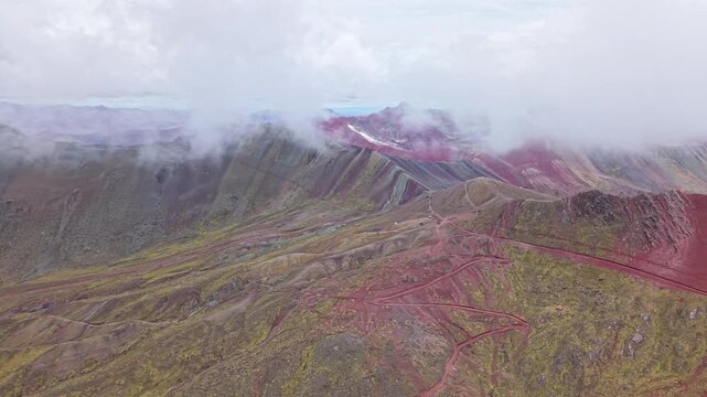 Aerial view of Vinicunca (Rainbow Mountain) and the Red Valley near Cusco, Peru, showing the distinctive multicolored mineral slopes and surrounding Andean landscape.