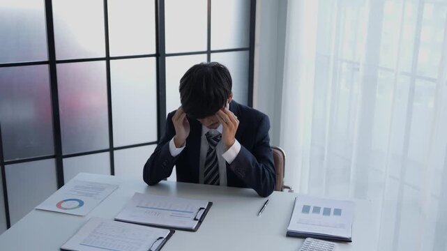 Stressed businessman holding head hard working in office