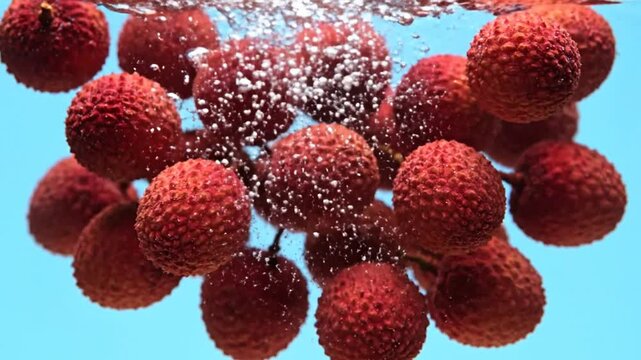 Juicy lychee fruits in a refreshing splash of water, creating a vibrant display of health and hydration, ideal for summer fruit and drink visuals