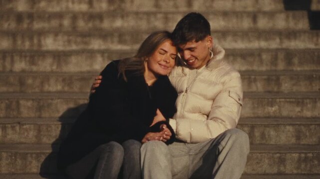 Showcasing a romantic city trip concept with a couple in love sitting on steps in Paris The clip features a Super 8 film style handheld camera work blurry effect and warm lighting travel content relat