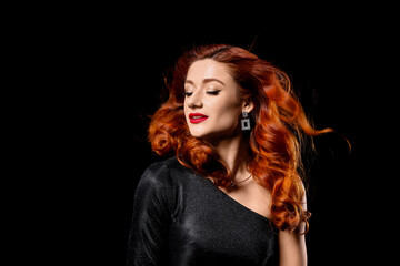 Naklejka premium Beautiful young woman with red wavy hair on black background