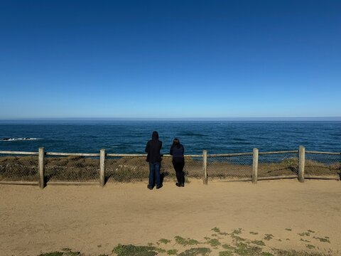 A couple looking at the Pacific Ocean and the clear blue sky