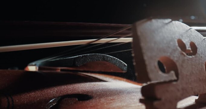 Person playing violin on classic theatre stage during music concert, closeup slow motion shot
