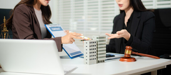 Fototapeta premium Real estate lawyer reviewing property contract with building model and gavel, concept of investment agreement, mortgage consultation, legal compliance