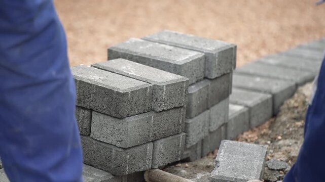 Installing new sidewalk made of concrete interlocking paving blocks, slow motion