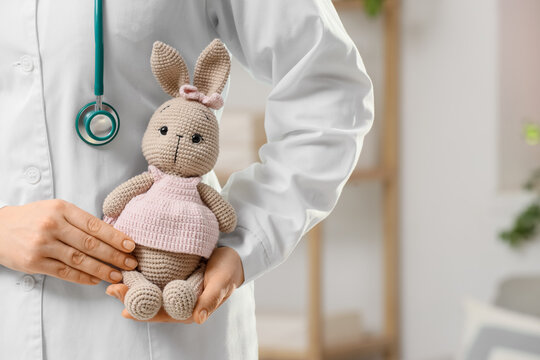 Female pediatrician with toy bunny in clinic, closeup