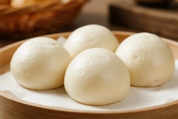 Steamed buns on a wooden plate with parchment paper
