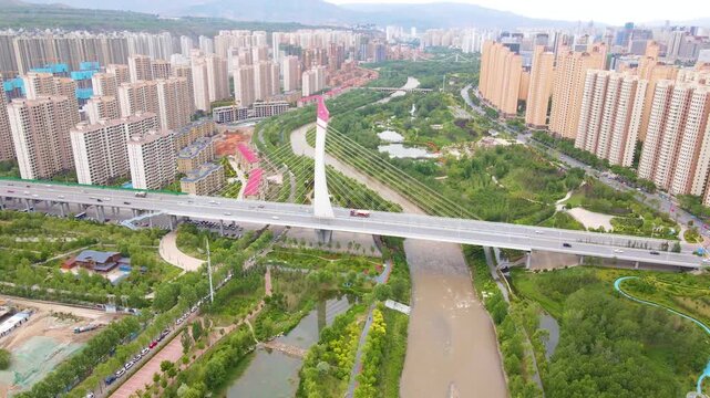 Stunning aerial drone footage of Xining city showcasing modern architecture, illuminated highway bridges, and vibrant night lights against the mountainous Qinghai landscape.